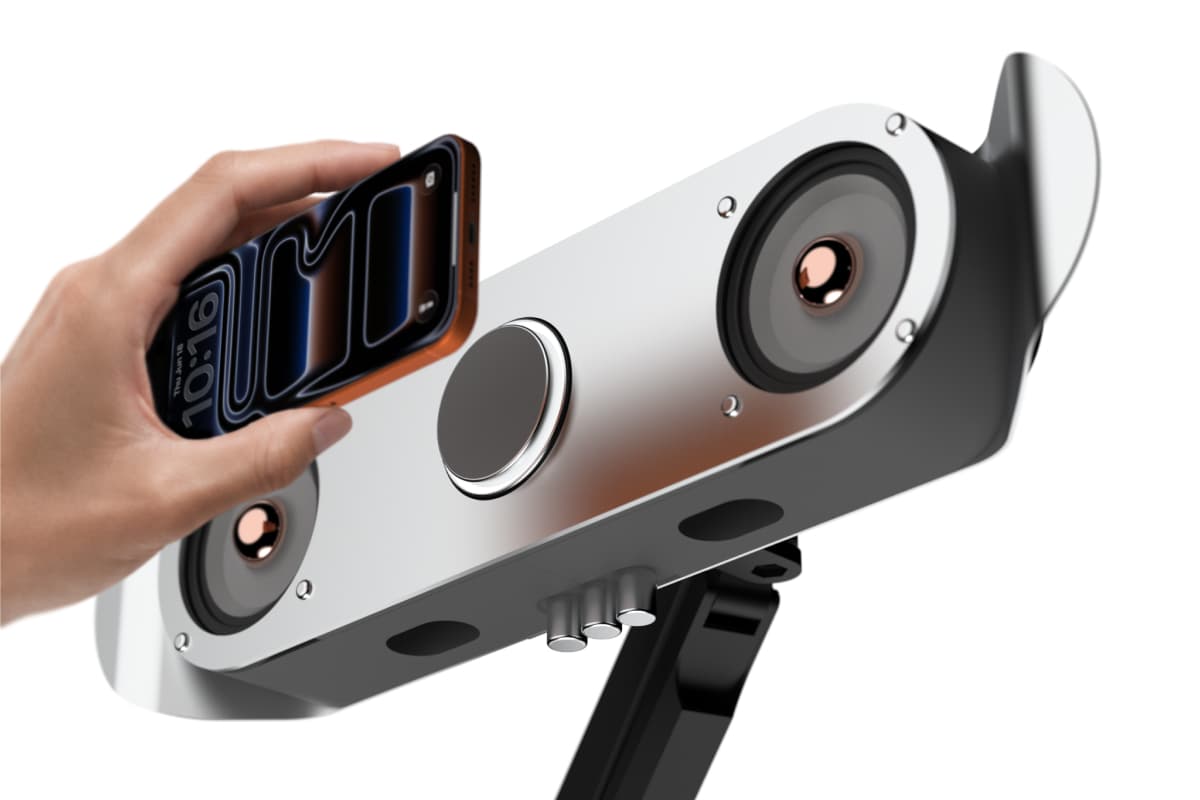 스마트폰을 VESA Based Floating Speaker 중앙의 MagSafe 충전면에 가까이 가져가는 장면